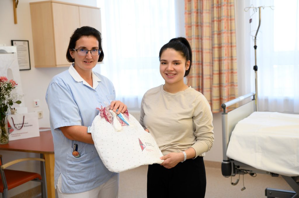 DGKP Eva Willinger übergibt das Willkommensgeschenk an eine Mutter.